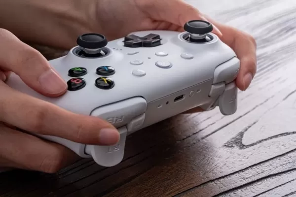 木製デスクの上に置かれた白色のゲームコントローラー