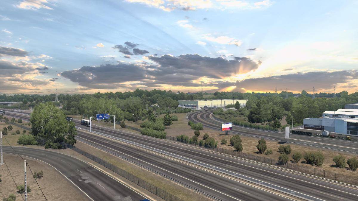 Sun shining through clouds above a highway